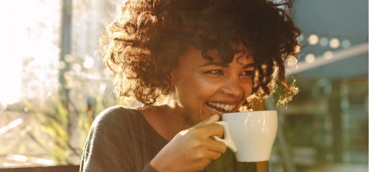 Woman drinking coffee in the morning sunlight – exploring the link between caffeine and bruxism