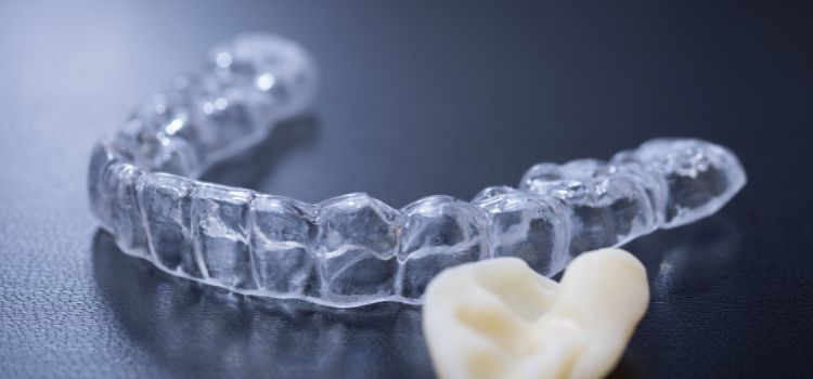 Clear dental night guard with an impression mold on a dark surface