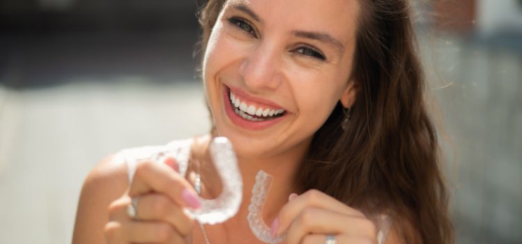 Smiling woman holding a clear night guard